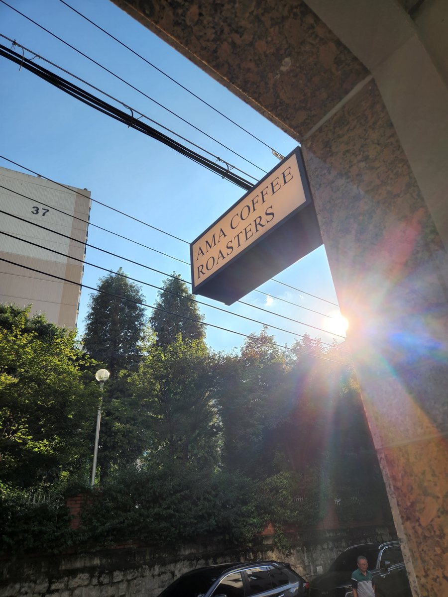 햇빛 속 AMA COFFEE ROASTERS 간판
